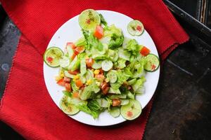 arabe salade avec concombre, tomate, citron et chou servi dans plat isolé sur rouge tapis Haut vue sur table arabe nourriture photo