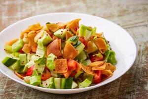 fatoosh salade ou fatoush avec concombre, tomate, caraquets, chou et feuilles servi dans plat isolé sur table Haut vue de arabe nourriture photo