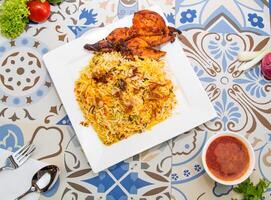 poulet biryani riz avec frit oignon et anacardier des noisettes servi dans plat isolé sur table Haut vue de arabe nourriture photo