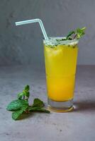 en bonne santé passion fruit Mojito Frais jus servi dans verre avec menthe paille côté vue sur gris Contexte photo