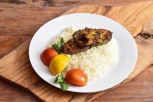 Roi poisson riz avec tomate et citron vert servi dans plat isolé sur en bois table Haut vue milieu est le déjeuner nourriture photo