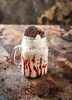 oreo Milk-shake avec Chocolat et fouetté crème servi dans pot isolé sur foncé Contexte côté vue de en bonne santé boisson photo