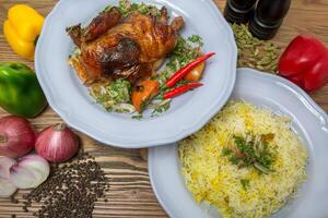 moitié grillé poulet avec Pulao riz biryani, noir poivre, cloche poivrons, tomate et oignon servi dans plat isolé sur table Haut vue de arabe nourriture photo