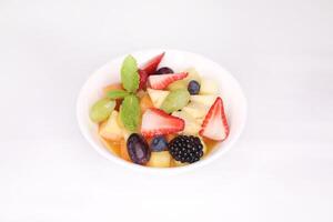 mixte fruit salade avec pomme, raisins, fraise, myrtille, pêche et morus Alba servi dans plat isolé sur Contexte côté vue de arabe nourriture photo