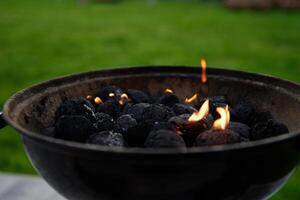 brûlant charbons pour barbecue pendant une pique-nique photo