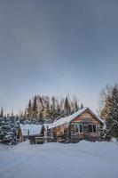 cabane en bois rond canadien pendant l'hiver photo