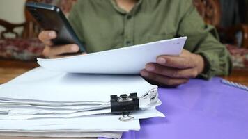 homme d'affaire en train de préparer rapports papiers. piles de inachevé document atteint avec papier agrafe. photo