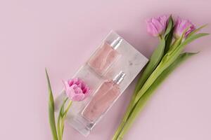 deux différent bouteilles de Rose eau, produits de beauté, parfum mensonge sur une marbre blanc podium parmi printemps fleurs. Haut voir. parfum concept. photo