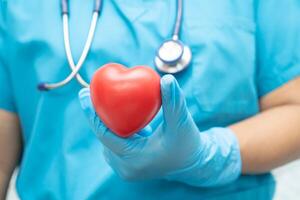 médecin tenant un coeur rouge dans la salle d'hôpital, concept médical solide et sain. photo