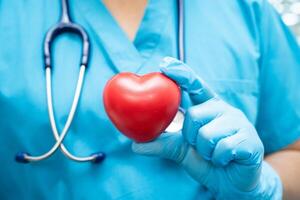 médecin tenant un coeur rouge dans la salle d'hôpital, concept médical solide et sain. photo