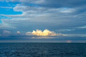 le des nuages avec lumière du soleil au dessus le mer. photo