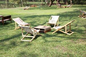 en bois pique-nique chaise et table sur une vert Prairie avec des arbres sur Contexte photo