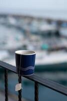 Matin fermer thé dans tasse, lever du soleil bokeh surplombant port vues dans Taïwan photo