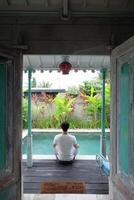villa bien-être, asiatique homme modèle pratiquant yoga, lotus pose par piscine, bali Indonésie photo