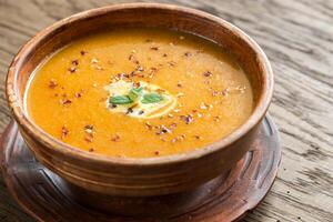 bol de épicé citrouille crème soupe sur le en bois table photo