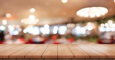 vide en bois table Haut avec lumières bokeh sur brouiller restaurant Contexte. photo