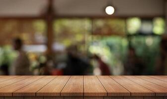 vide en bois table Haut avec lumières bokeh sur brouiller restaurant Contexte. photo