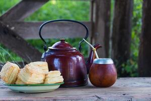 camarade et bouilloire avec une assiette de salé argentin des biscuits et yerba camarade infusion photo