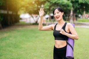 yoga fille. aptitude et bien-être présenté comme une svelte asiatique fille des exercices avec une tapis dans le parc à le coucher du soleil. embrassement santé et actif vie. photo