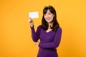 dans sa élégant violet chemise et des lunettes de soleil contre jaune, une femme présente un vide affiche conseil, votre Toile pour affaires ou personnel expression. photo