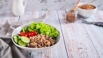 bol avec sarrasin, concombre, Cerise tomate et salade sur le table la toile bannière photo