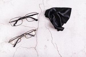 entier lunettes, cassé des lunettes et nettoyage tissu sur une gris Contexte Haut vue photo