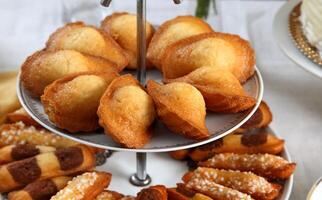 Madeleine, délicieux français petit gâteau dans arrangement sur le table photo