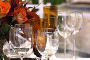 sophistiqué les tables avec assiettes, coutellerie et bien des lunettes fermer photo