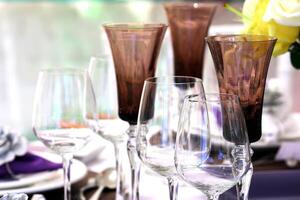 sophistiqué les tables avec assiettes, coutellerie et bien des lunettes fermer photo