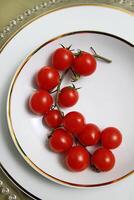 assiette avec tomates sur table avec panetton, lunettes, fruit et du vin photo