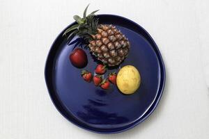 bleu céramique assiette avec nombreuses différent des fruits photo