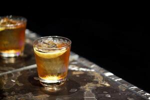 parrain, classique boisson avec scotch whisky, Amaretto et bitter dans une verre avec la glace photo