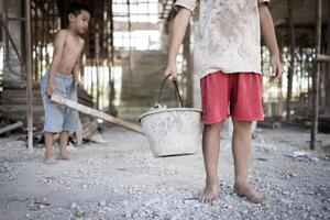 les enfants pauvres du chantier de construction ont été forcés de travailler. concept contre le travail des enfants. l'oppression ou l'intimidation du travail forcé parmi les enfants. traite des êtres humains. photo