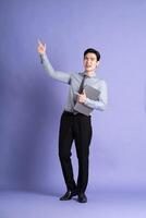portrait de asiatique Masculin homme d'affaire permanent et posant sur violet Contexte photo