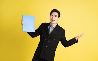 portrait de asiatique Masculin homme d'affaire. portant une costume et posant sur une Jaune Contexte photo