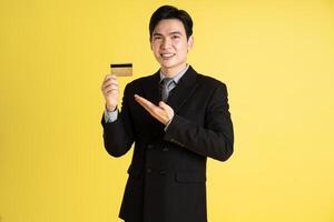 portrait de asiatique Masculin homme d'affaire. portant une costume et posant sur une Jaune Contexte photo