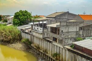rangée de Maisons sur le banques de le bengawan solo rivière photo