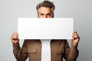 portrait de une homme en portant une blanc horizontal feuille de papier avec une endroit pour l'écriture et maquette. photo