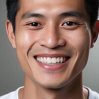 un asiatique à la recherche homme souriant et ayant magnifique blanc et tout droit dents. photo