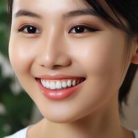 une fermer de le tête de une souriant asiatique fille avec magnifique blanc et tout droit dents, parfait pour La publicité pour dentistes. photo