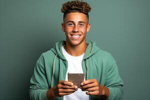 portrait de une gars sur une vert Contexte avec une téléphone dans le sien mains. photo