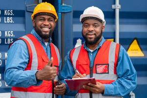 portrait de deux africain ingénieur ou contremaître porte ppe vérification récipient espace de rangement avec cargaison récipient Contexte à le coucher du soleil. logistique global importer ou exportation livraison industriel concept. photo