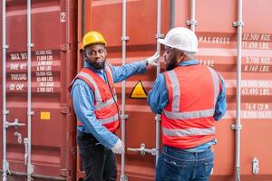 portrait de deux africain ingénieur ou contremaître porte ppe vérification récipient espace de rangement avec cargaison récipient Contexte à le coucher du soleil. logistique global importer ou exportation livraison industriel concept. photo