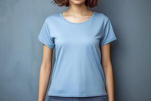 Jeune femme portant Vide bleu T-shirt dans de face de le gris mur. maquette T-shirt modèle. photo