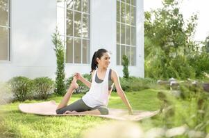 Jeune femme dans tenue de sport Faire méditation entraine toi et yoga Extérieur, en bonne santé mode de vie, mental santé concept. photo