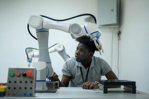 stagiaire la robotique ingénieur apprentissage avec programmation et manipuler robot main, industriel la robotique conception, haute technologie facilité, moderne machine apprentissage. Masse production automatiques. photo