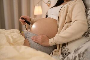 magnifique Enceinte femme en utilisant lampe de poche sur ventre à stimuler une de bébé développement, la fertilité infertilité traitement, FIV, futur maternité concept photo