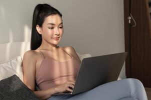 Jeune asiatique femme travail avec portable dans vivant pièce à Accueil photo