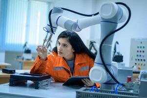 femelle la robotique ingénieur travail avec programmation et manipuler robot main, industriel la robotique conception, haute technologie facilité, moderne machine apprentissage. Masse production automatiques. photo