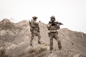 soldats dans camouflage uniformes visée avec leur fusilsprêt à Feu pendant militaire opération dans le désert soldats formation dans une militaire opération photo